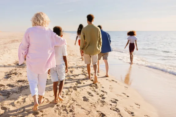 Little boy and girl having a fun day at the beach with their parents and grandparents